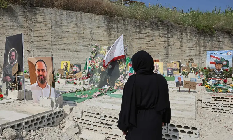A woman sits inside a temporary cemetery built for Hezbollah fighters and civilians killed during the ongoing war, in the southern coastal Lebanese city of Sidon on June 11, 2026. &mdash; AFP