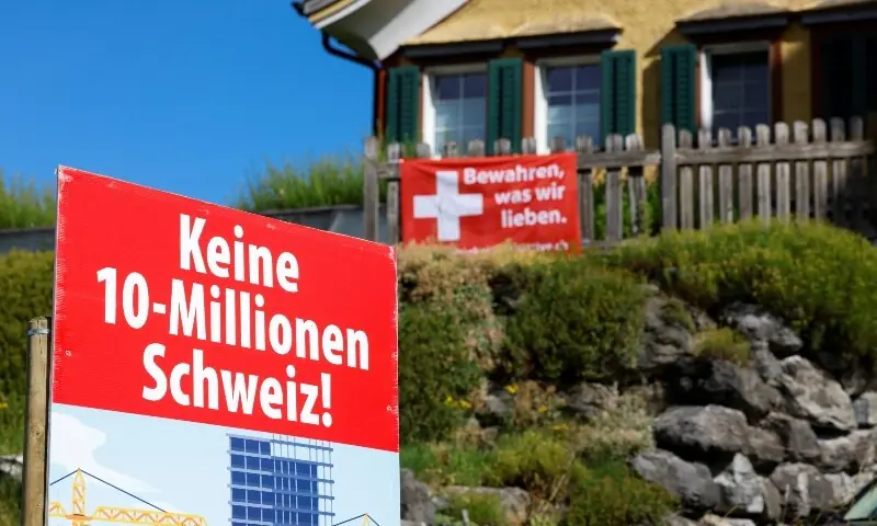 Signs stand in front of a building, on the day of the vote on a plan backed by the right-wing Swiss People’s Party (SVP) to limit population growth to 10 million inhabitants, in Appenzell, Switzerland, June 14. — Reuters