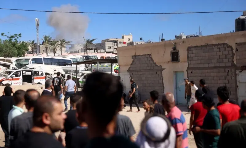 Palestinians look on as smoke rises following an Israeli military strike in Khan Yunis, southern Gaza Strip on June 14, 2026. &mdash;AFP