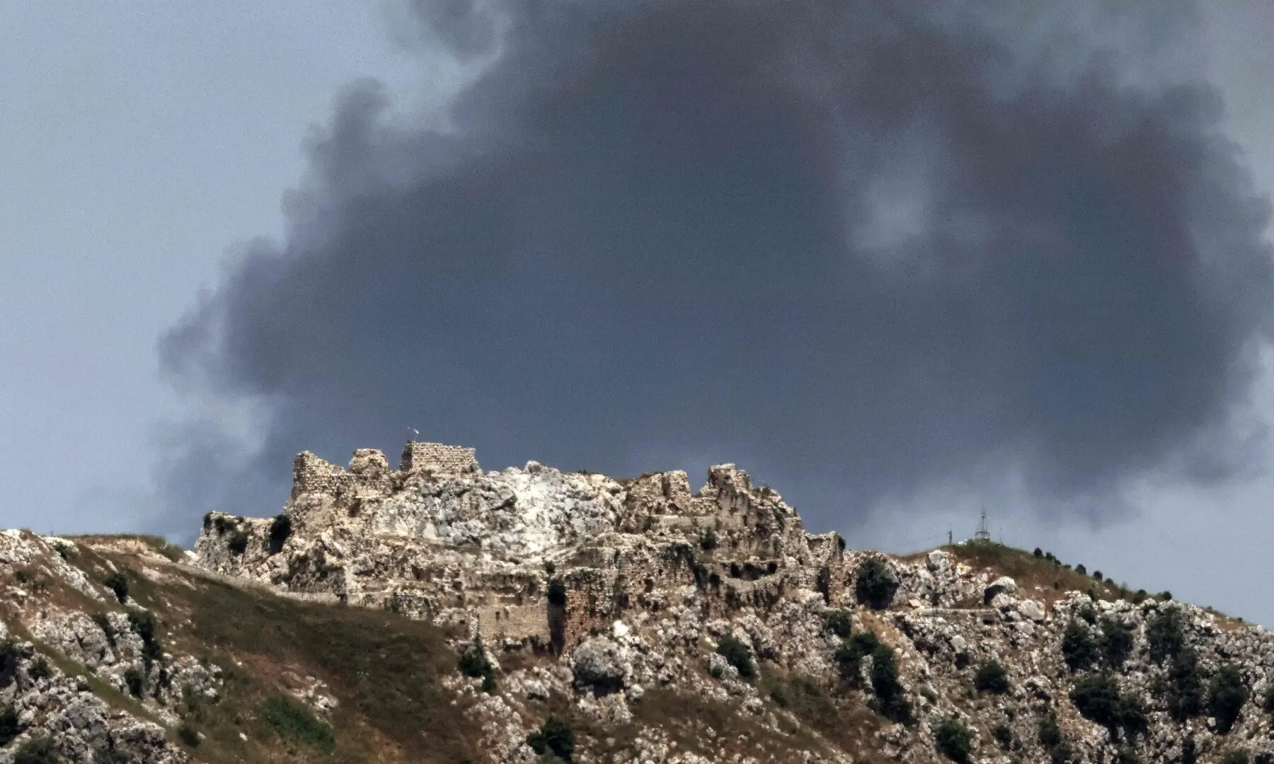 This picture taken from a position in the Upper Galilee in northern Israel, near the Israel-Lebanon border on June 17, 2026, shows smoke billowing in the distance behind the medieval Beaufort Castle in southern Lebanon. &mdash; AFP