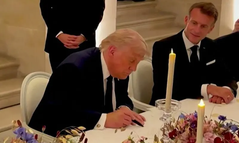 US President Donald Trump signs the deal with Iran at Versailles, as French President Emmanuel Macron looks on.—AFP/Reuters US President Donald Trump signs the deal with Iran at Versailles, as French President Emmanuel Macron looks on.—AFP/Reuters