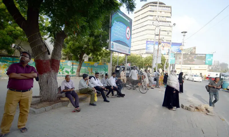 Commuters wait for public buses near I.I. Chundrigar Road as transport operators observe a strike against the e-challan system.&mdash;PPI