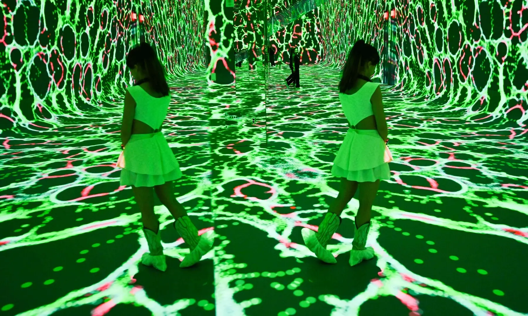 A person is reflected in a mirror while walking through immersive visualisations from the inaugural exhibition Machine Dreams: Rainforest are projected at Dataland, the Museum of AI Arts, in Los Angeles, California on June 9, 2026. — AFP
