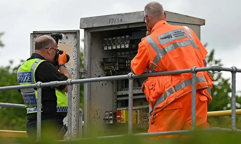 A crime scene manager from the British Transport Police photographs the inside of an electrical box at the side of a train track near to where two East Midlands Railway (EMR) trains crashed into each other on June 19, 2026, south of Bedford in central England on June 20, 2026. — AFP