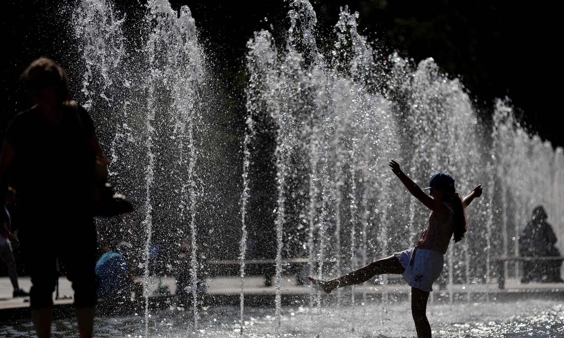 A girl plays in water jets during a heatwave in Strasbourg, eastern France, on June 20, 2026, as France issues a red heatwave alert across more than a third of the country for today. — AFP A girl plays in water jets during a heatwave in Strasbourg, eastern France, on June 20, 2026, as France issues a red heatwave alert across more than a third of the country for today. — AFP