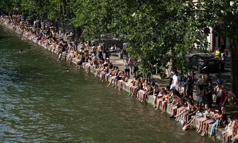 Swimmers sunbath on the banks of the Canal Saint-Martin as France experiences a heatwave in Paris on June 20. — AFP Swimmers sunbath on the banks of the Canal Saint-Martin as France experiences a heatwave in Paris on June 20. — AFP