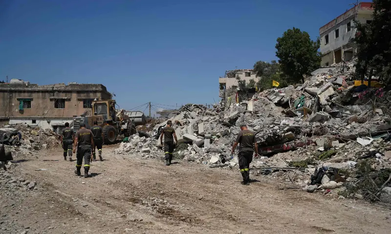 Lebanese civil defence workers walk behind a bulldozer as it removes the rubble from the main market place destroyed by the Israeli military in the southern city of Nabatieh on June 21, 2026. &mdash; AFP