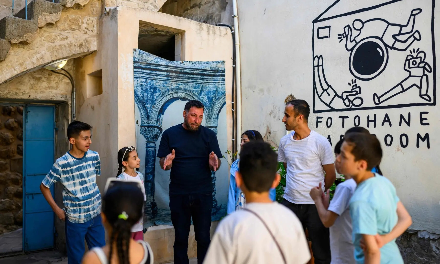 Co-founder of the project, photographer and educator Amar Kilic speaks to children during a workshop held as part of Fotohane Darkroom project in Mardin, southeastern Turkiye, on June 13, 2026. — AFP