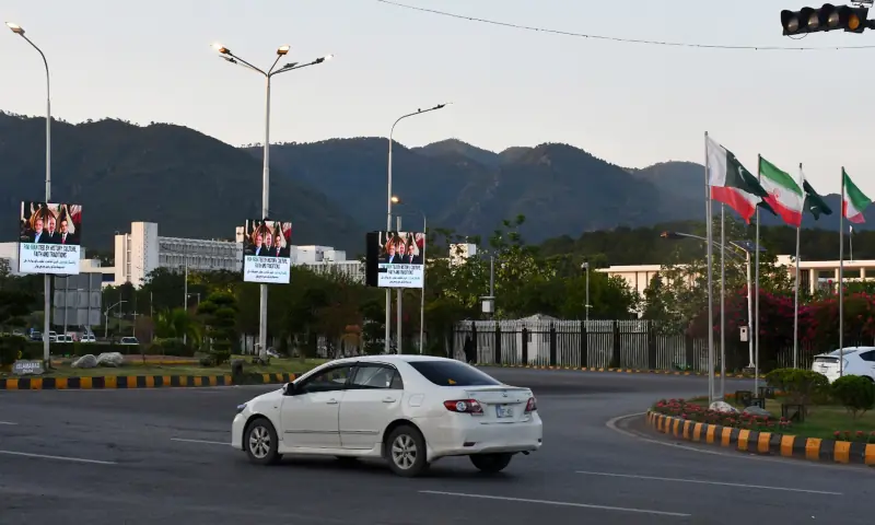 A commuter travels past roads lined with the flags of Pakistan and Iran as Islamabad prepares to welcome Iranian President Masoud Pezeshkian, in Islamabad on June 22. &mdash; White Star