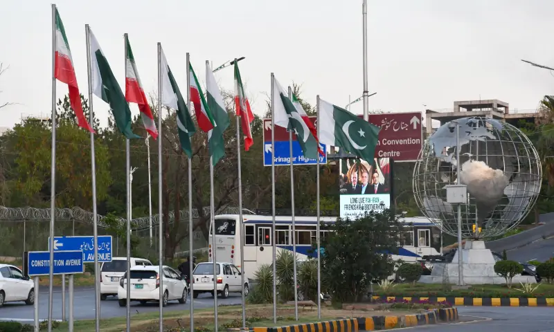 Commuters travel along roads lined with the flags of Pakistan and Iran as Islamabad prepares to welcome Iranian President Masoud Pezeshkian, in Islamabad on June 22. &mdash; White Star