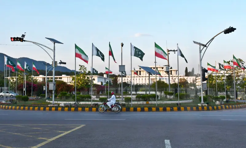A commuter travels past roads lined with the flags of Pakistan and Iran as Islamabad prepares to welcome Iranian President Masoud Pezeshkian, in Islamabad on June 22. &mdash; White Star
