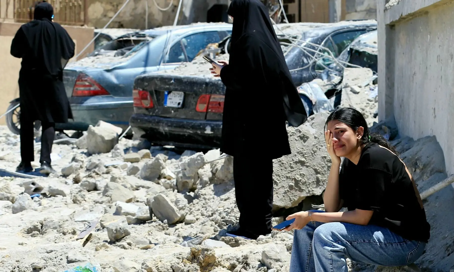A Lebanese woman weeps as she sits on the rubble at the site of an Israeli airstrike that targeted the southern Lebanese village of Qennarit on June 20, 2026. &mdash; AFP