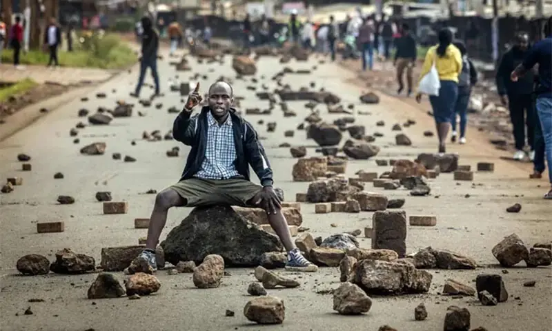 A protester chants anti-government slogans on a road blocked with stones to prevent traffic from passing during a transport strike in Nairobi, Kenya. — AFP/File