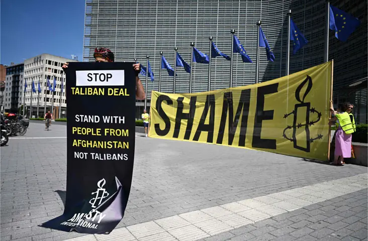 Brussels: An Amnesty International activist holds a banner in front of the EU Commission headquarters to protest against the meeting.—AFP Brussels: An Amnesty International activist holds a banner in front of the EU Commission headquarters to protest against the meeting.—AFP
