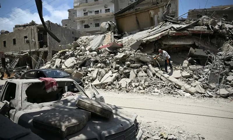 A man walks on the rubbles as he looks for items in a building hit in earlier Israeli military strikes on a neighbourhood in the southern Lebanese coastal city of Tyre on June 23, 2026. &mdash;Reuters