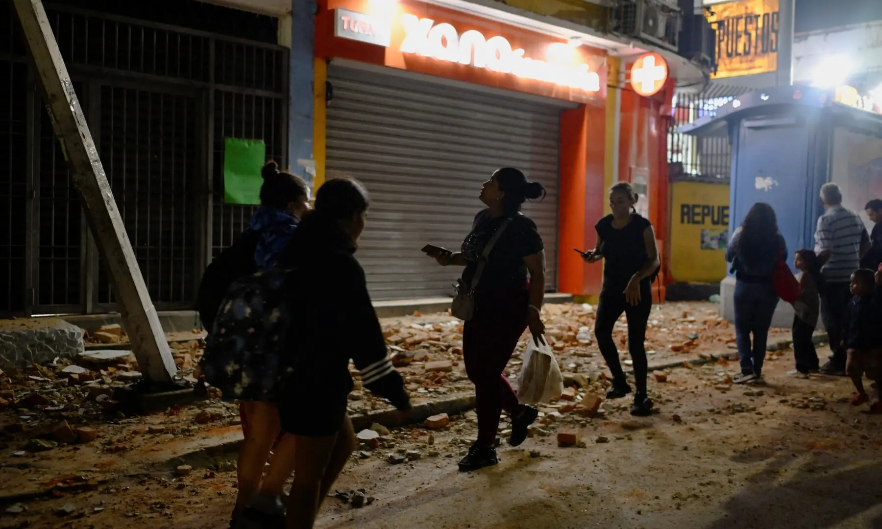  People walk past debris after an earthquake, in Caracas, Venezuela, June 24, 2026. &mdash;Reuters 