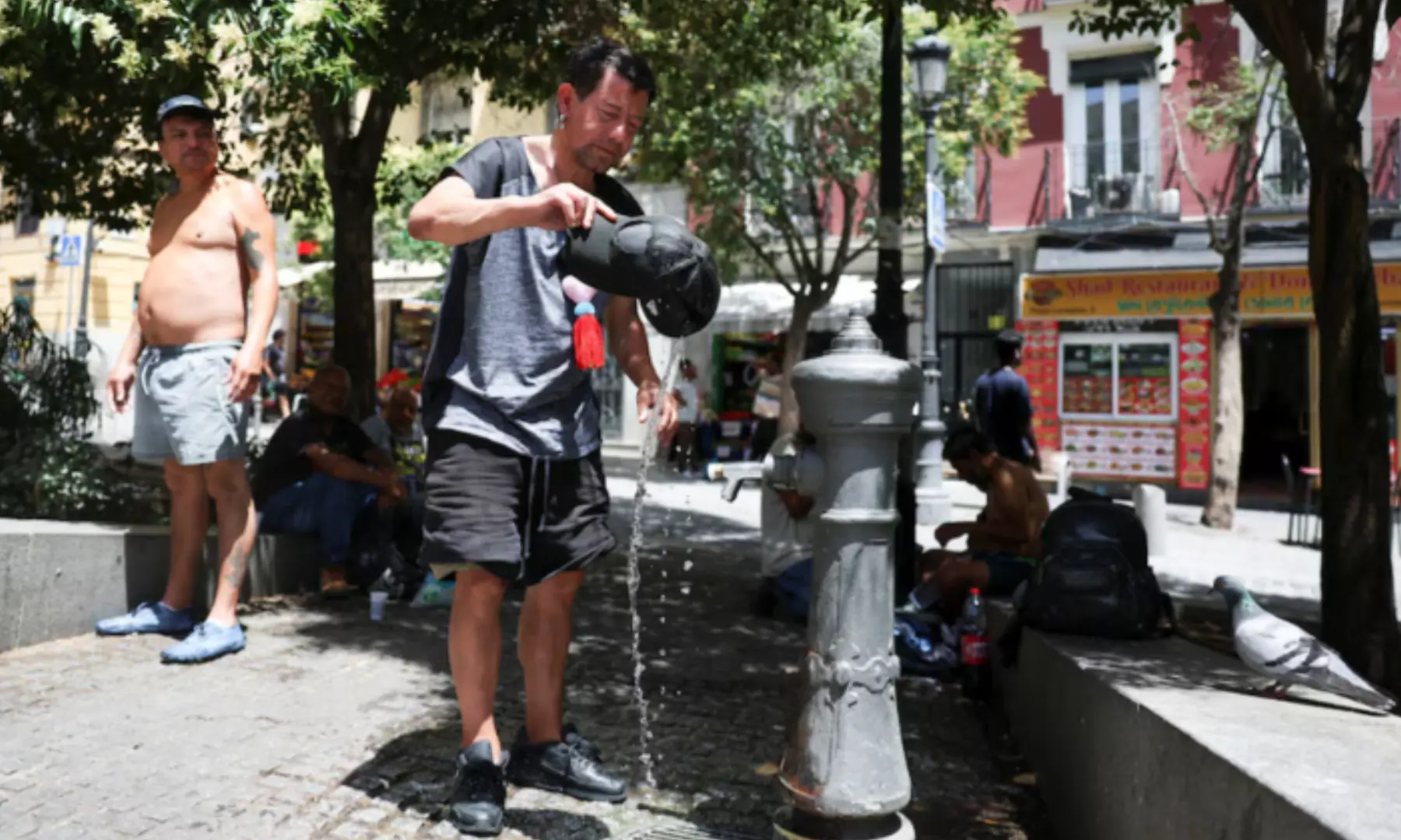 A man rinses his hat with water to cool off during a hot day amid a heatwave in Madrid, Spain on June 23, 2026. &mdash; Reuters/ File