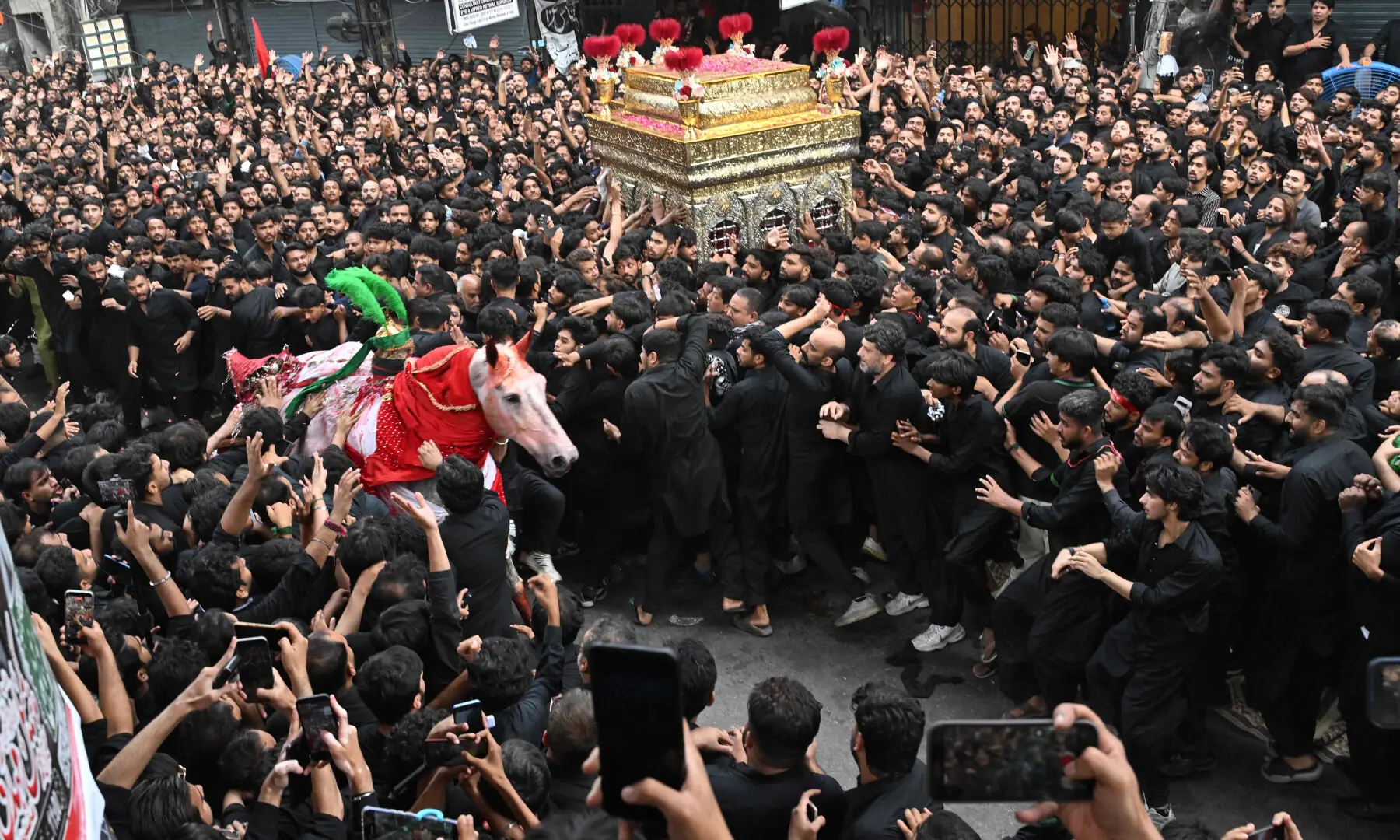 Mourners participate in a Muharram procession on the ninth day of Ashura in Lahore on June 25, 2026. &mdash; AFP