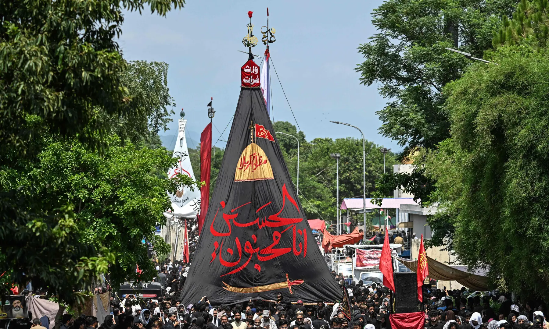 Muslims hold a religious flag as they take part in a procession on the ninth day of Muharram in Islamabad on June 25, 2026. &mdash; AFP