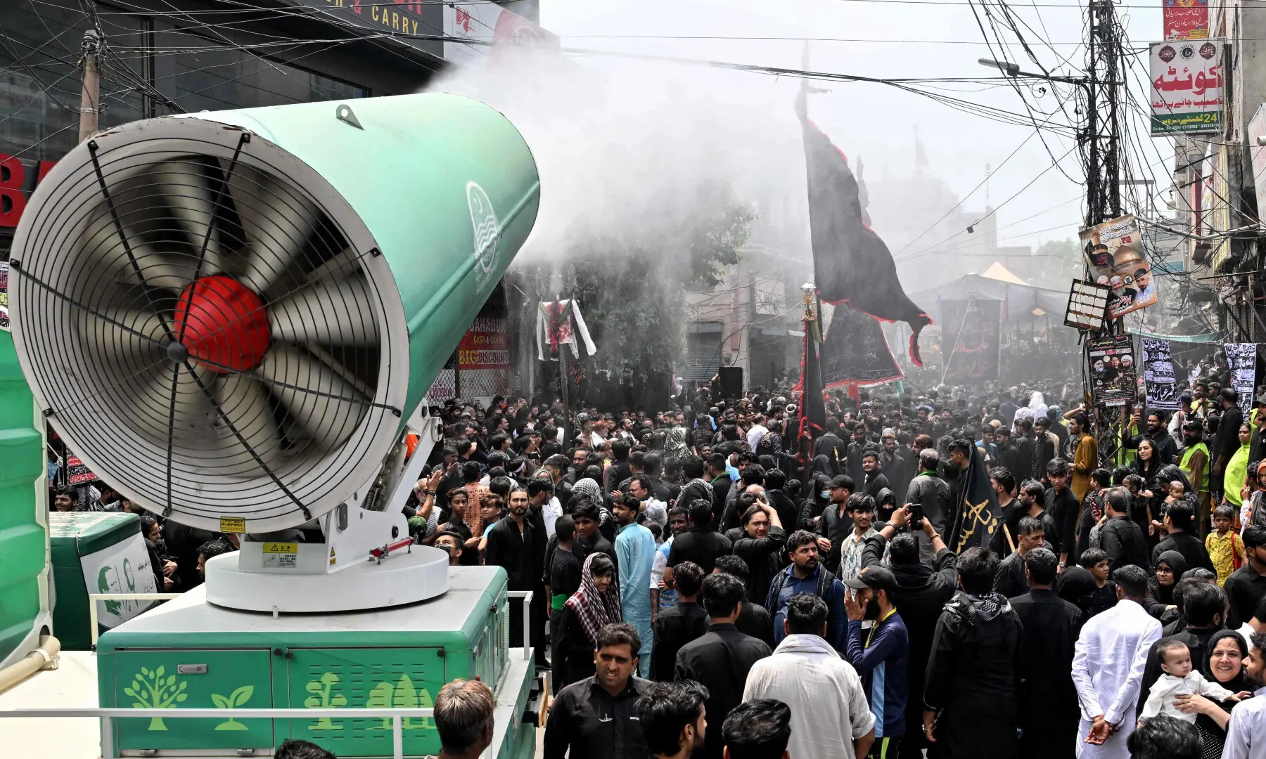 A mist cannon sprays water as Muslims take part in a religious procession on the ninth day of Muharram in Lahore on June 25, 2026. &mdash; AFP