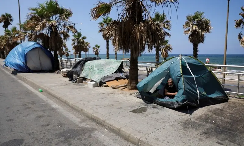 A man looks out from inside his tent, after Beirut municipality instructed displaced residents living on public sidewalks to move to official shelters, following the interim deal between the US and Iran, in Beirut, Lebanon, June 25, 2026. &mdash;Reuters