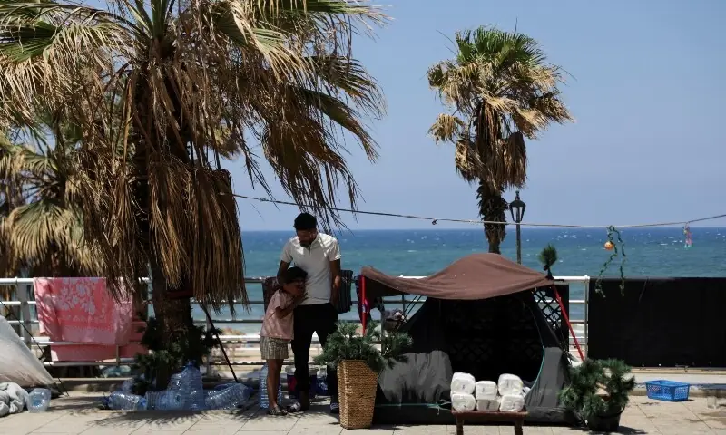 A man looks out from inside his tent, after Beirut municipality instructed displaced residents living on public sidewalks to move to official shelters, following the interim deal between the US and Iran, in Beirut, Lebanon, June 25, 2026. &mdash;Reuters
