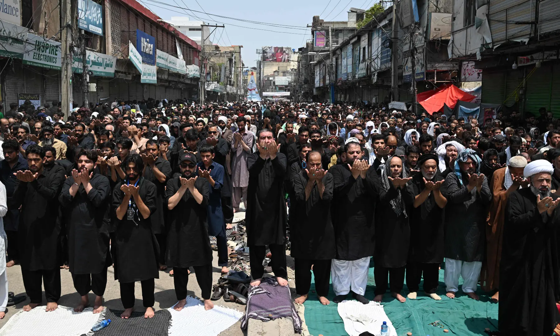 Mourners offer noon prayers during the Muharram procession on the tenth day of Ashura in Rawalpindi on June 26, 2026. &mdash; AFP