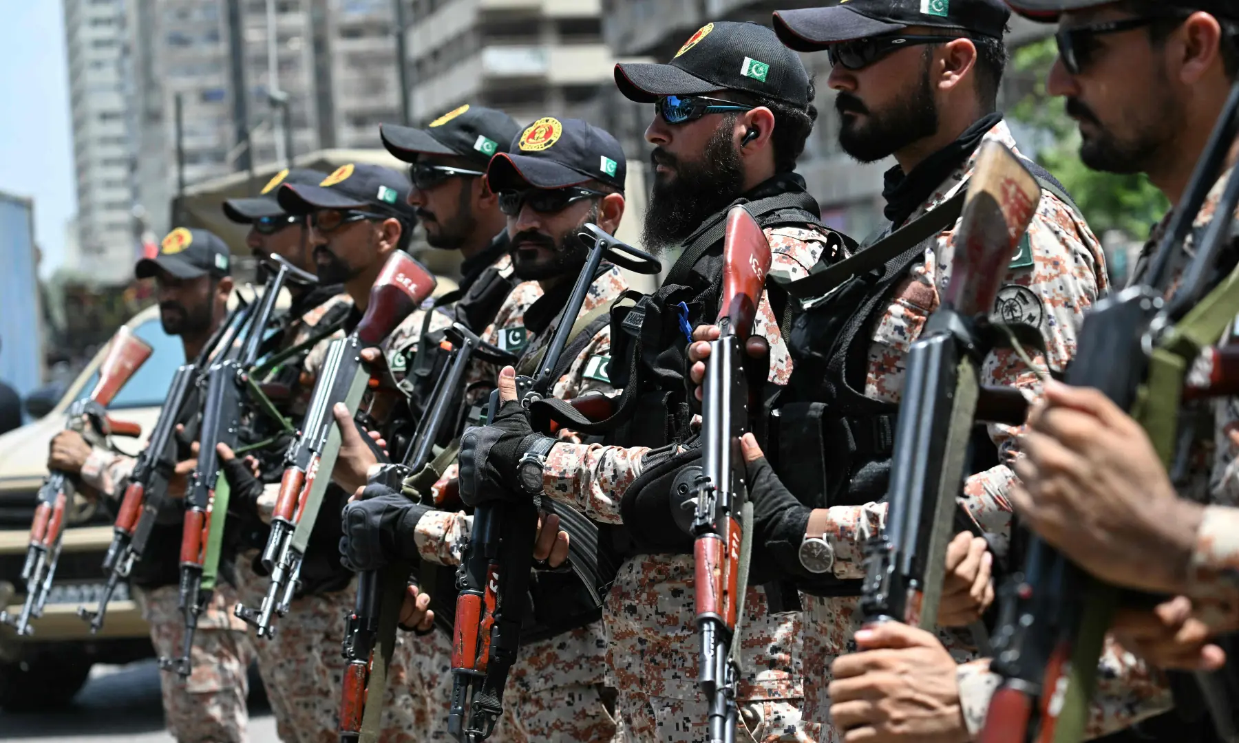 Security personnel stand guard as mourners march during a religious procession marking Ashura on the tenth day of Muharram in Karachi on June 26, 2026. &mdash; AFP