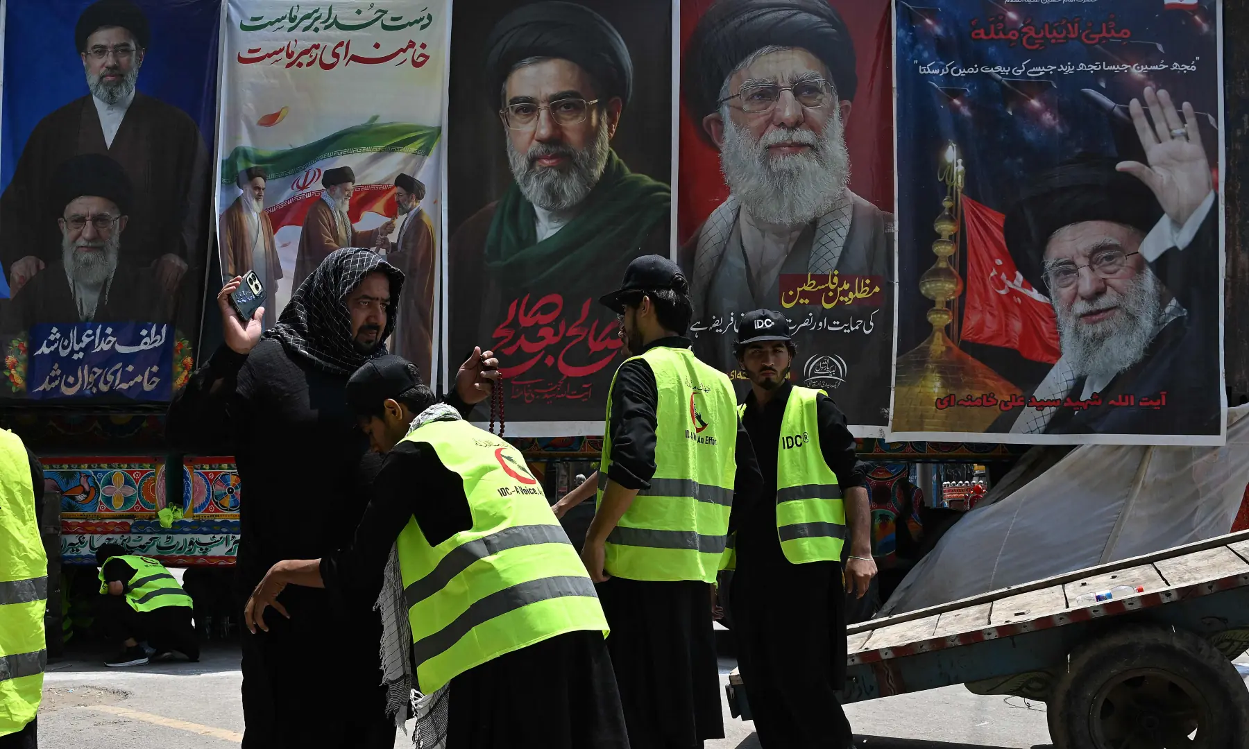 Volunteers frisk a mourner beside the posters of Iran&rsquo;s supreme leader Mojtaba Khamenei and late supreme leader Ayatollah Ali Khamenei during the Muharram procession on the tenth day of Ashura in Rawalpindi on June 26, 2026. &mdash; AFP