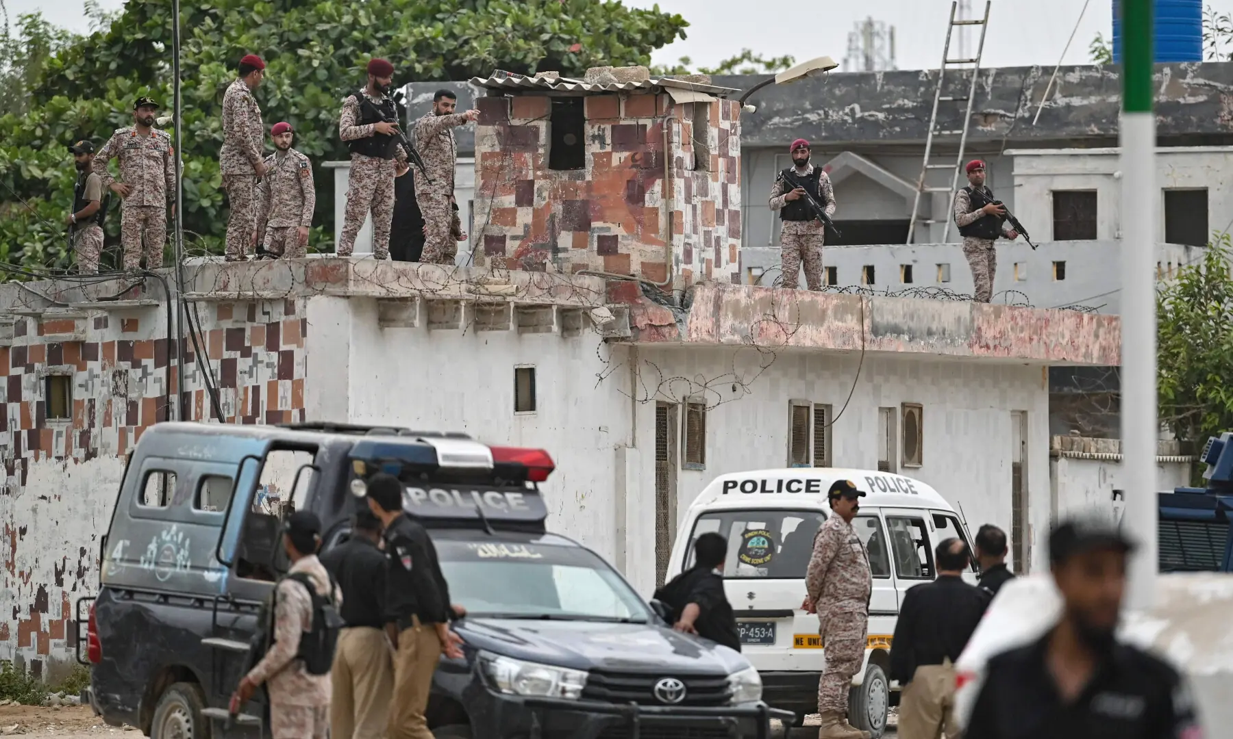 Security personnel inspect the rooftop of a compound at the end of a clearance operation following a terrorist attack in Karachi on June 28, 2026. &mdash; AFP