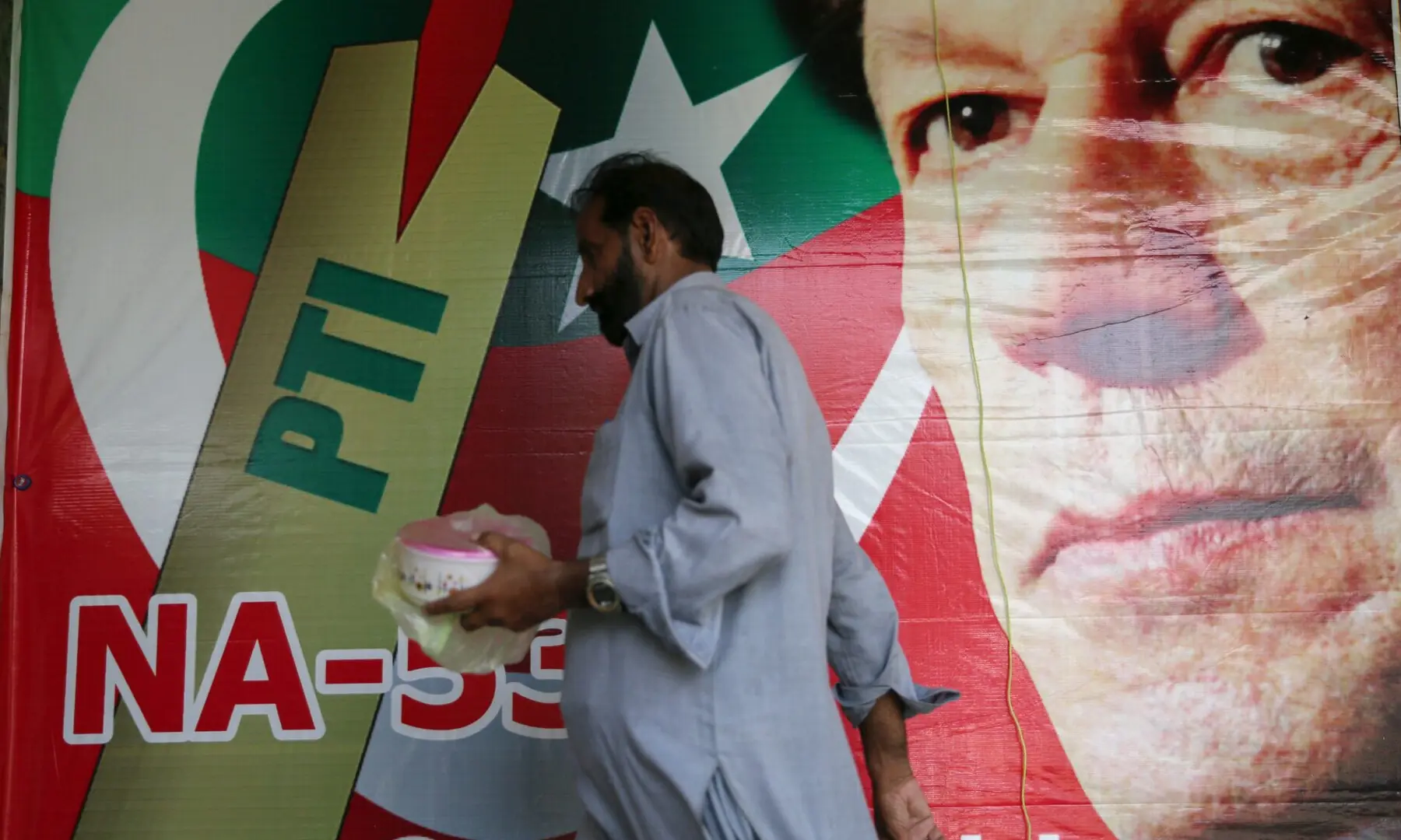 A man walks past an image of PTI founder Imran Khan at a market in Islamabad on July 27, 2018. &mdash; Reuters/File