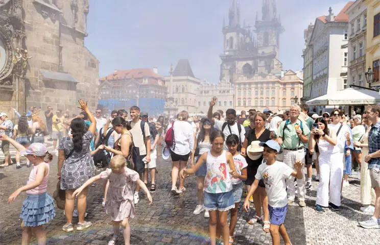 PEOPLE are sprayed with water to cool down during a hot day in Prague, the capital of Czechia.&mdash;Reuters