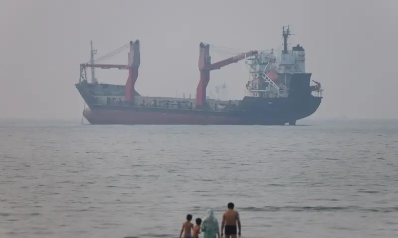 People ride motorbikes on the shore while vessels are in the Strait of Hormuz near the beach of Bandar Abbas, Iran, June 30, 2026. &mdash;Reuters