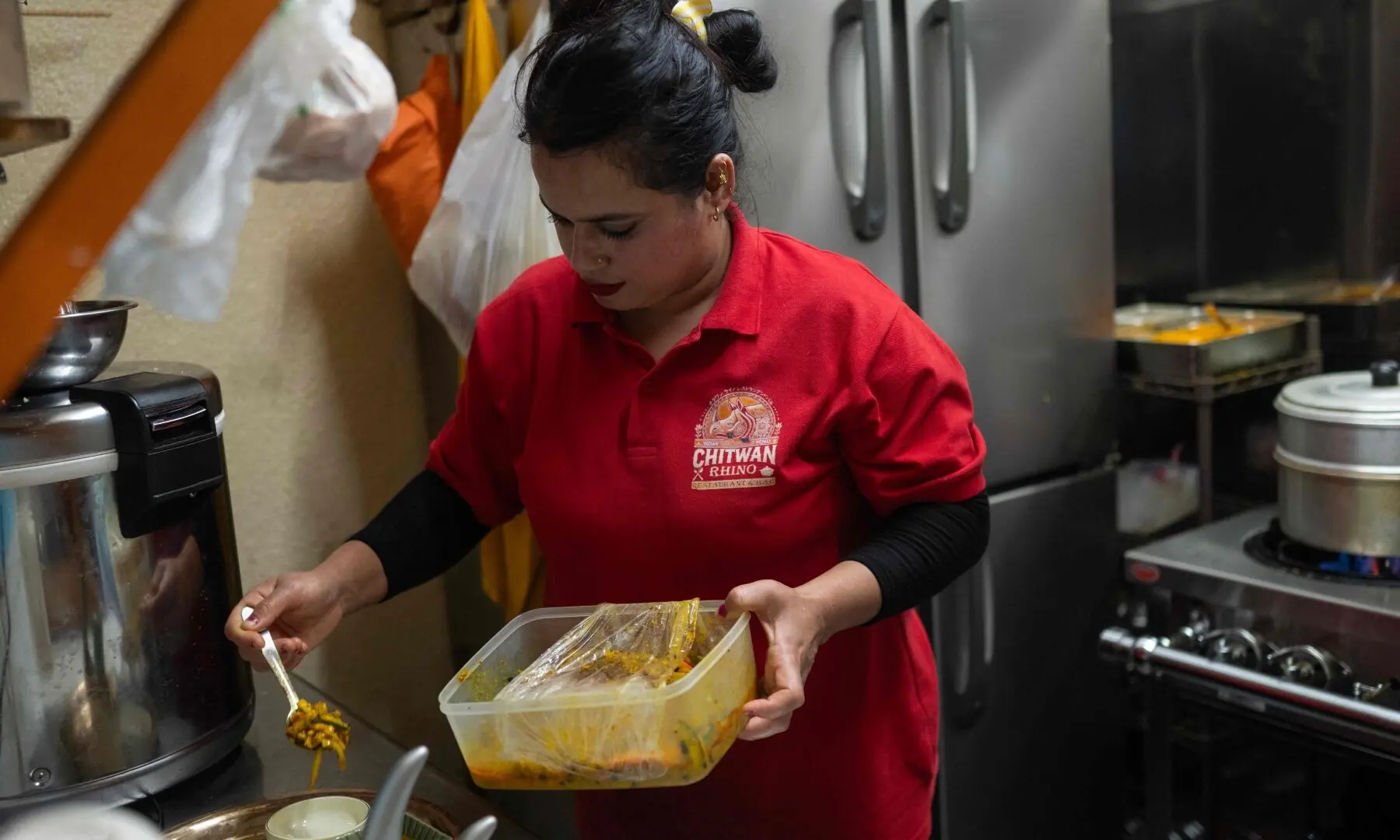 Gautam Kumal Shashi, the cook at Chitwan Rhino Restaurant and Bar, serves food in the Okubo–Shin area, one stop north of Shinjuku, in Tokyo on June 12, 2026, a neighbourhood known for its large immigrant communities, including Korean, Southeast Asian and South Asian residents. — AFP