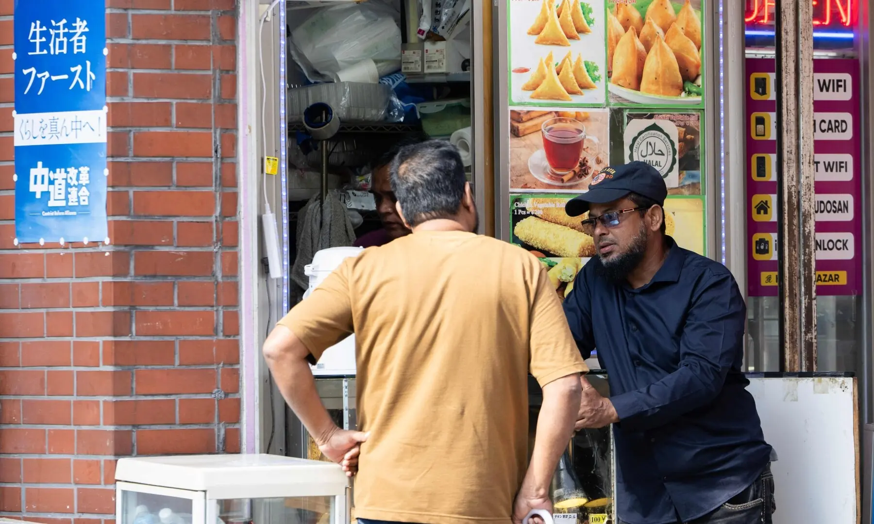 People talk outside of a South Asian restaurant north in the Okubo–Shin area in Tokyo on June 12, 2026, a neighbourhood known for its large immigrant communities, including Korean, Southeast Asian and South Asian residents. — AFP