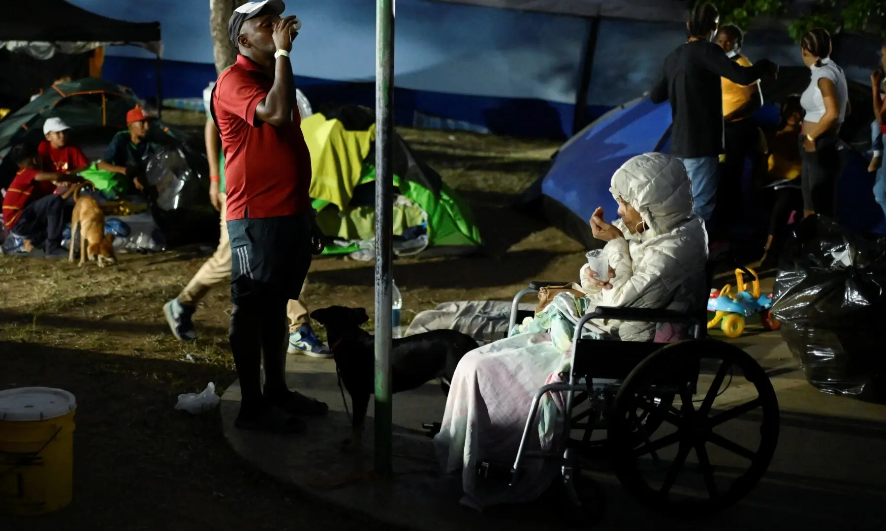 People who are displaced by the earthquakes that struck the country on June 24, drink beverages as they live in tents in a park, in Caracas, Venezuela, July 1, 2026. - Reuters
