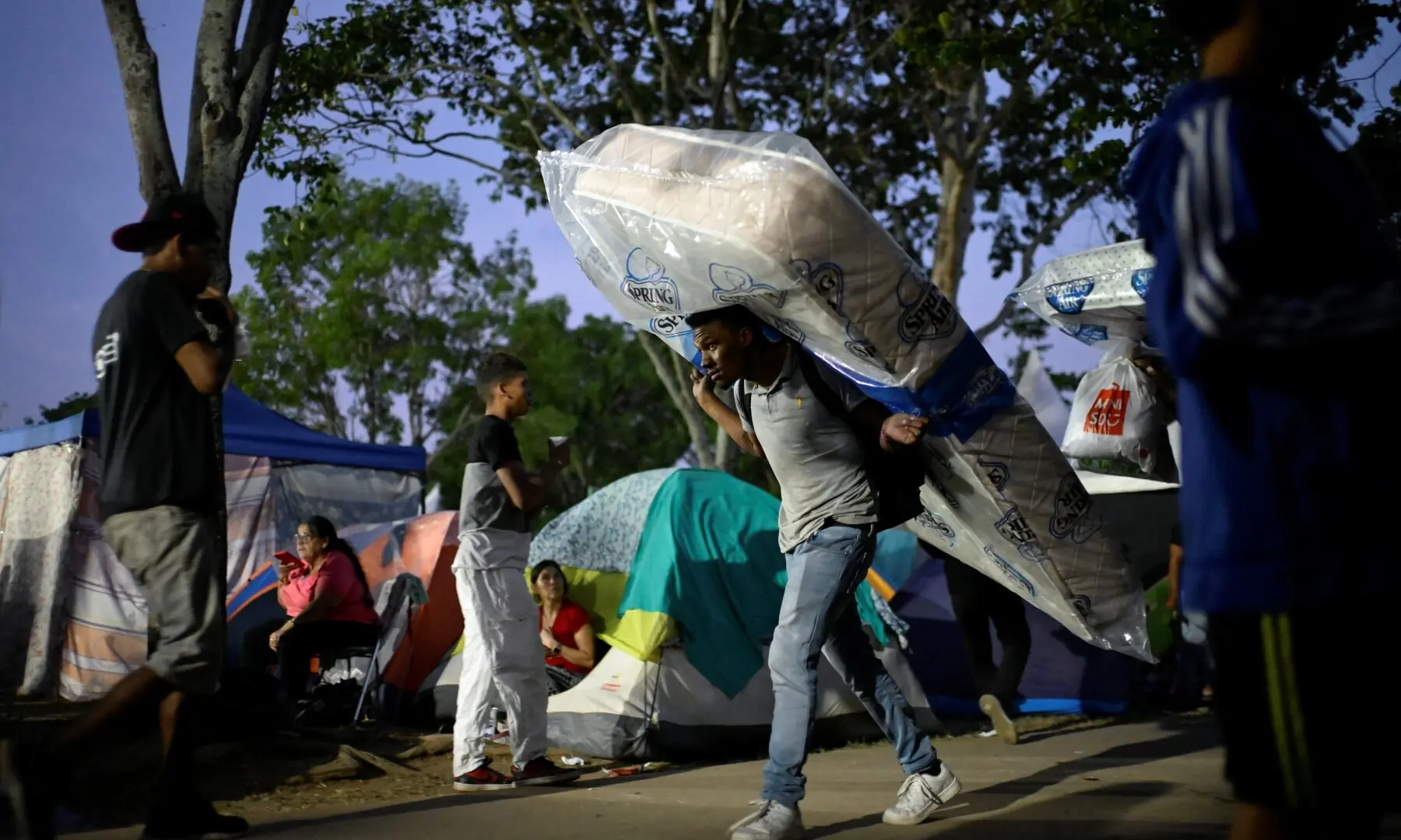 A man carries a mattress as people displaced by the earthquakes that struck the country on June 24, live in tents in a park, in Caracas, Venezuela, July 1, 2026. - Reuters