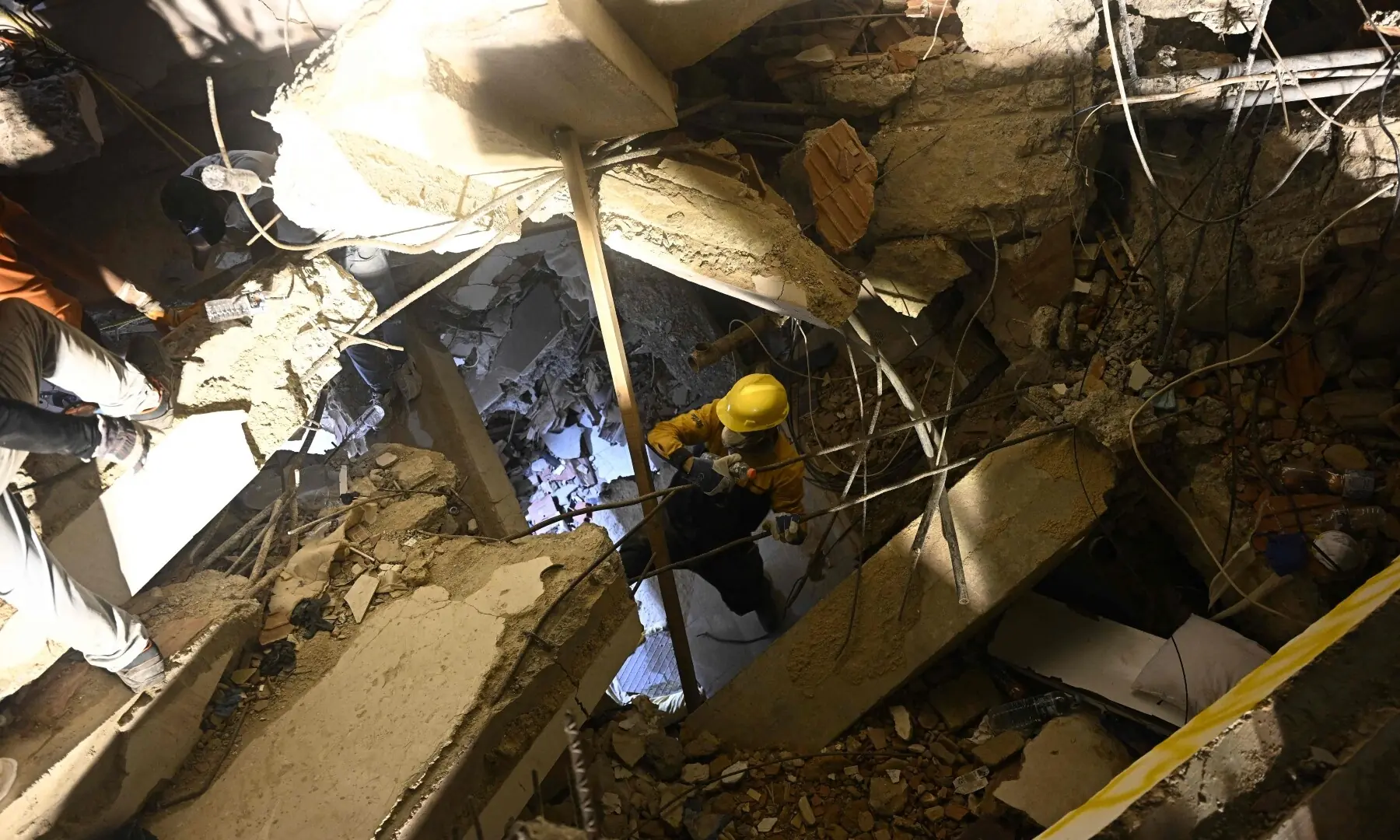 A person searches for a deceased relative among the debris of a collapsed building in the Los Corales neighbourhood of Caraballeda, La Guaira State, Venezuela on July 1, 2026, following the June 24 twin earthquakes. - AFP