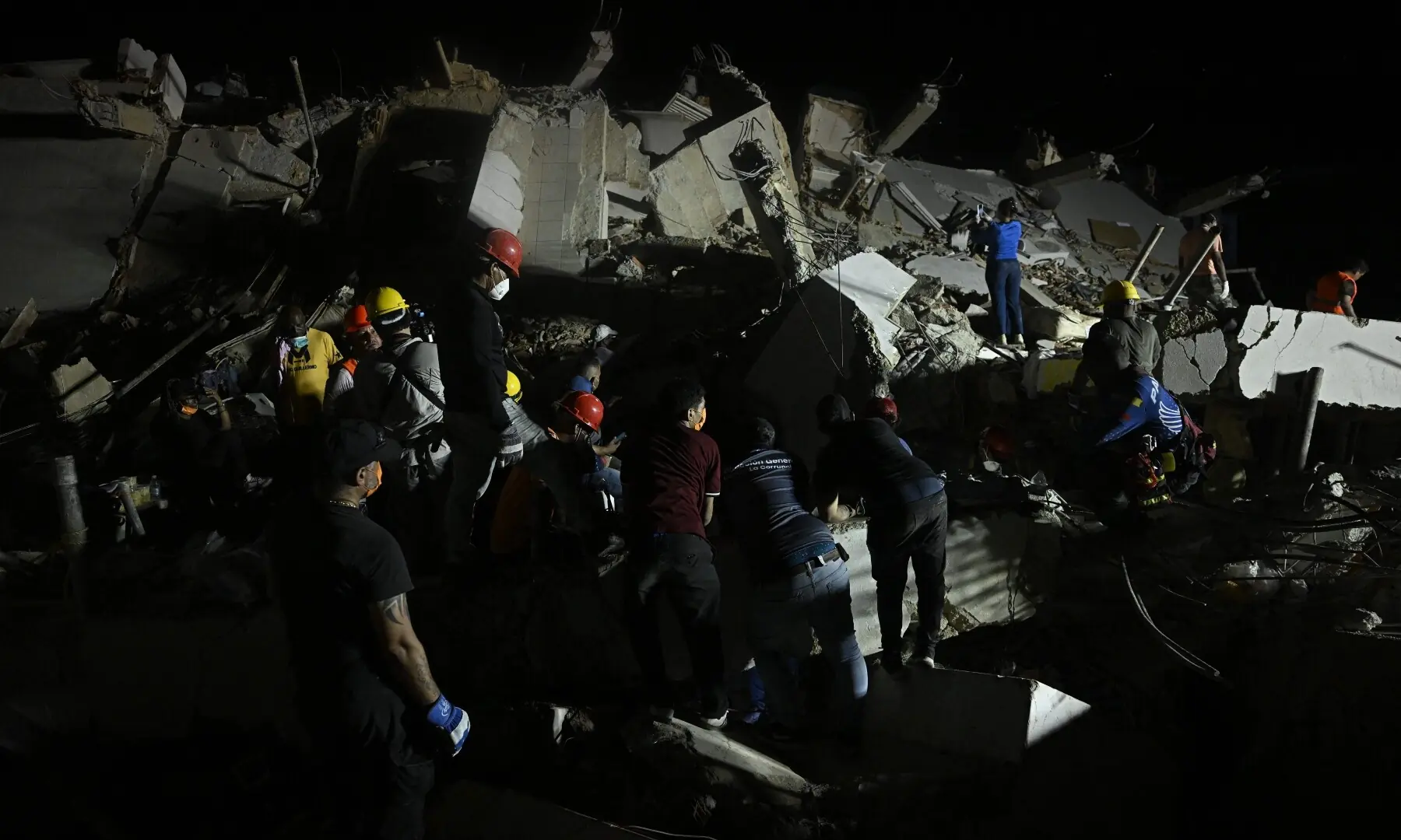 People search for their deceased relatives among the debris of a collapsed building in the Los Corales neighbourhood of Caraballeda, La Guaira State, Venezuela on July 1, 2026, following the June 24 twin earthquakes. - AFP