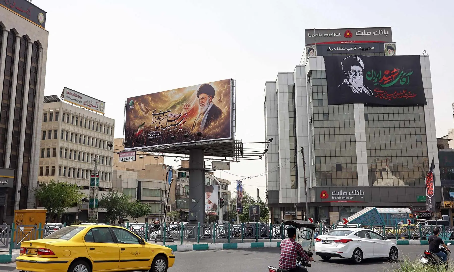 Commuters drive past giant billboards bearing pictures of Iran’s late supreme leader Ayatollah Ali Khamenei ahead of his funeral, in Tehran, Iran on July 2, 2026. — AFP