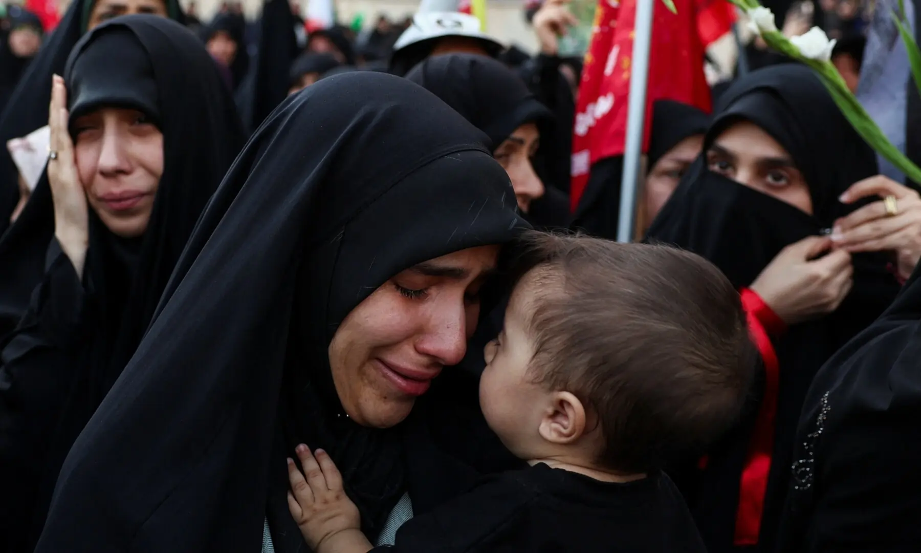 A woman mourns while carrying a child as people gather on the day of a public farewell ceremony to pay their respects to assassinated Supreme Leader Ayatollah Ali Khamenei at the Imam Khomeini Grand Mosalla, in Tehran, Iran July 4, 2026. &mdash; Reuters