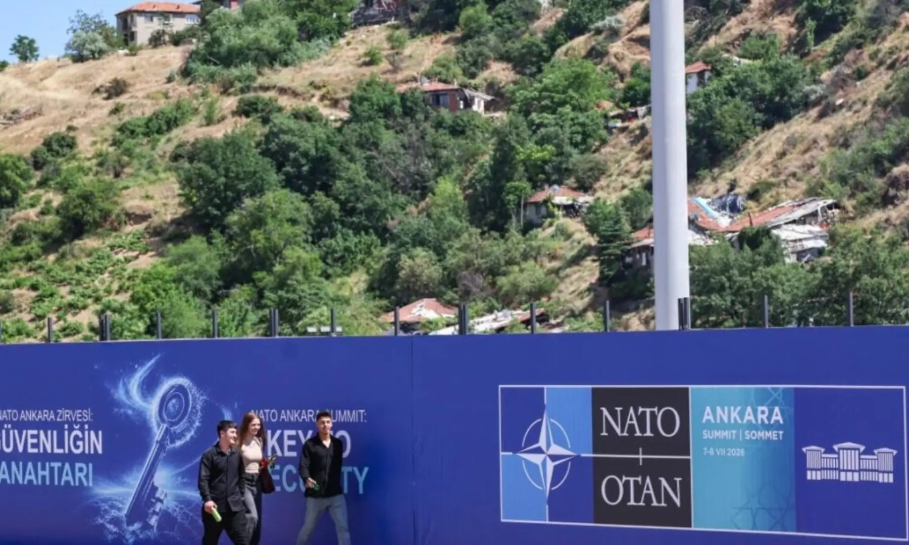 Local residents walk past billboards with the slogans &ldquo;Key to Peace,&rdquo; &ldquo;Key to Security,&rdquo; and &ldquo;Shared Future in Peace&rdquo;, displayed along the boulevard on the protocol route ahead of the Nato Summit in Ankara, on 26 June 2026.. &mdash;AFP