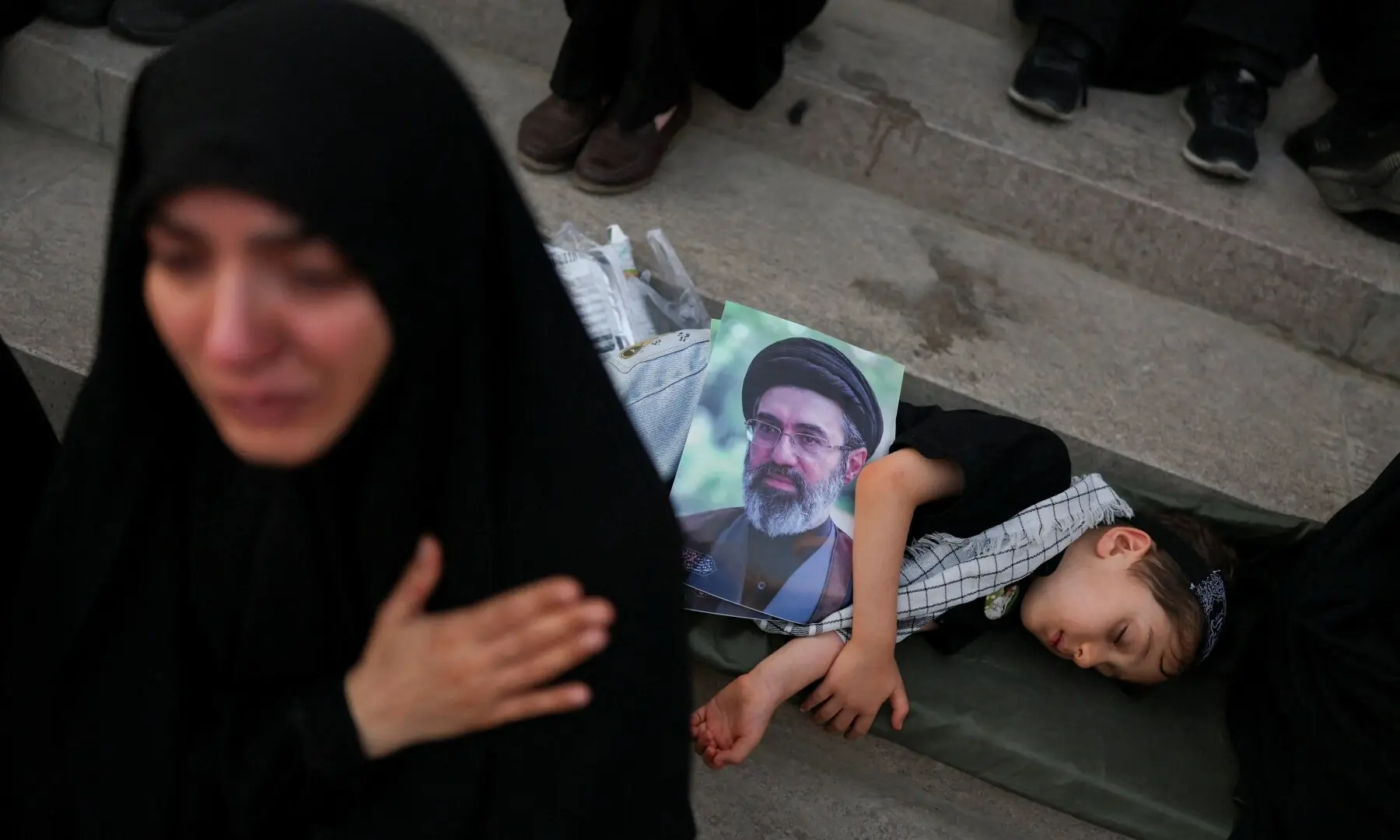 A child holding an image of Iran&rsquo;s Supreme Leader Mojtaba Khamenei rests, on the day of a public farewell ceremony to pay their respects to late Supreme Leader Ayatollah Ali Khamenei, who was killed on February 28 in Israeli and US airstrikes, at the Imam Khomeini Grand Mosalla, in Tehran, Iran on July 4, 2026. &mdash; Reuters