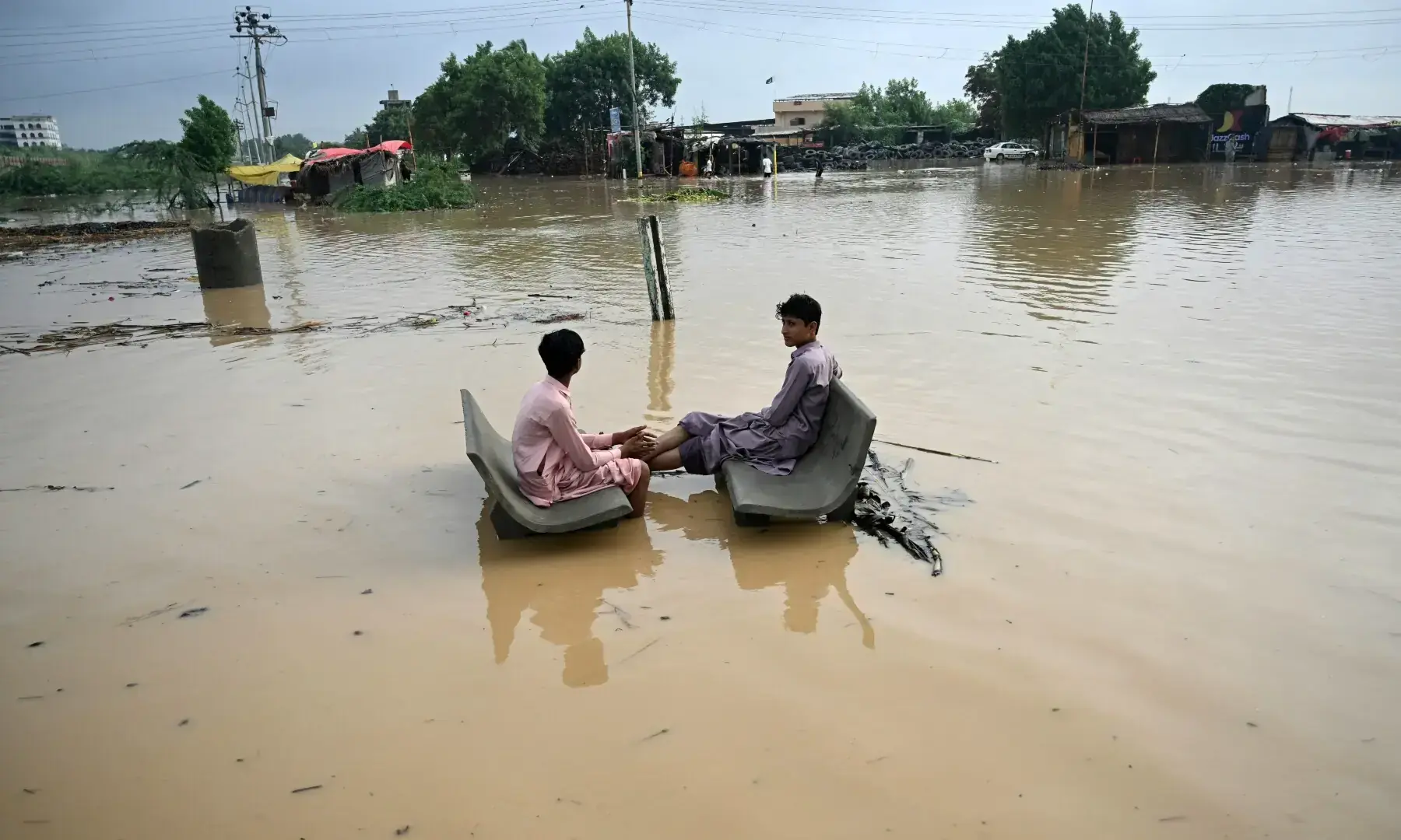 Youths rest on inundated benches along a flooded street after rainfall in Karachi on Sept 10, 2025. — AFP/File Youths rest on inundated benches along a flooded street after rainfall in Karachi on Sept 10, 2025. — AFP/File