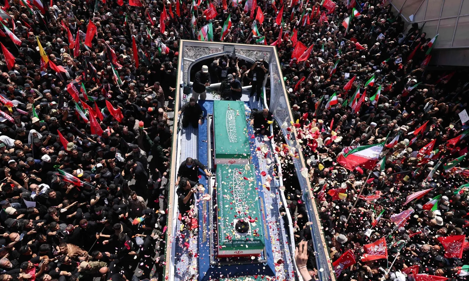 Mourners, some throwing flower petals, gather near the coffins of Iran&rsquo;s slain supreme leader Ali Khamenei and members of his family during a funeral procession in Tehran on July 6, 2026. &mdash; AFP
