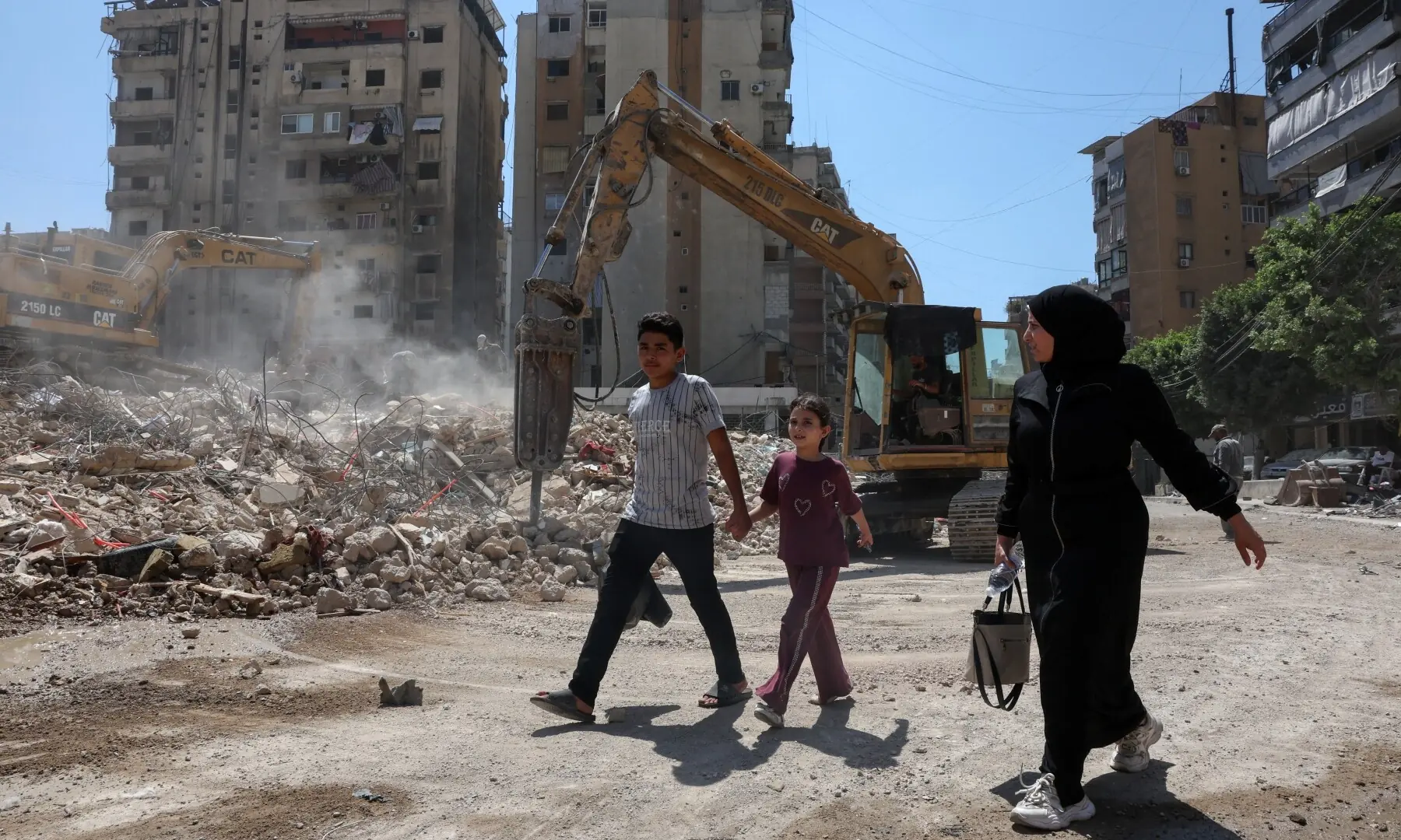 People walk past the rubble of buildings damaged in Israeli strikes in Beirut&rsquo;s southern suburbs, following a ceasefire agreement between Lebanon and Israel, in Beirut, Lebanon, July 6, 2026. &mdash; Reuters