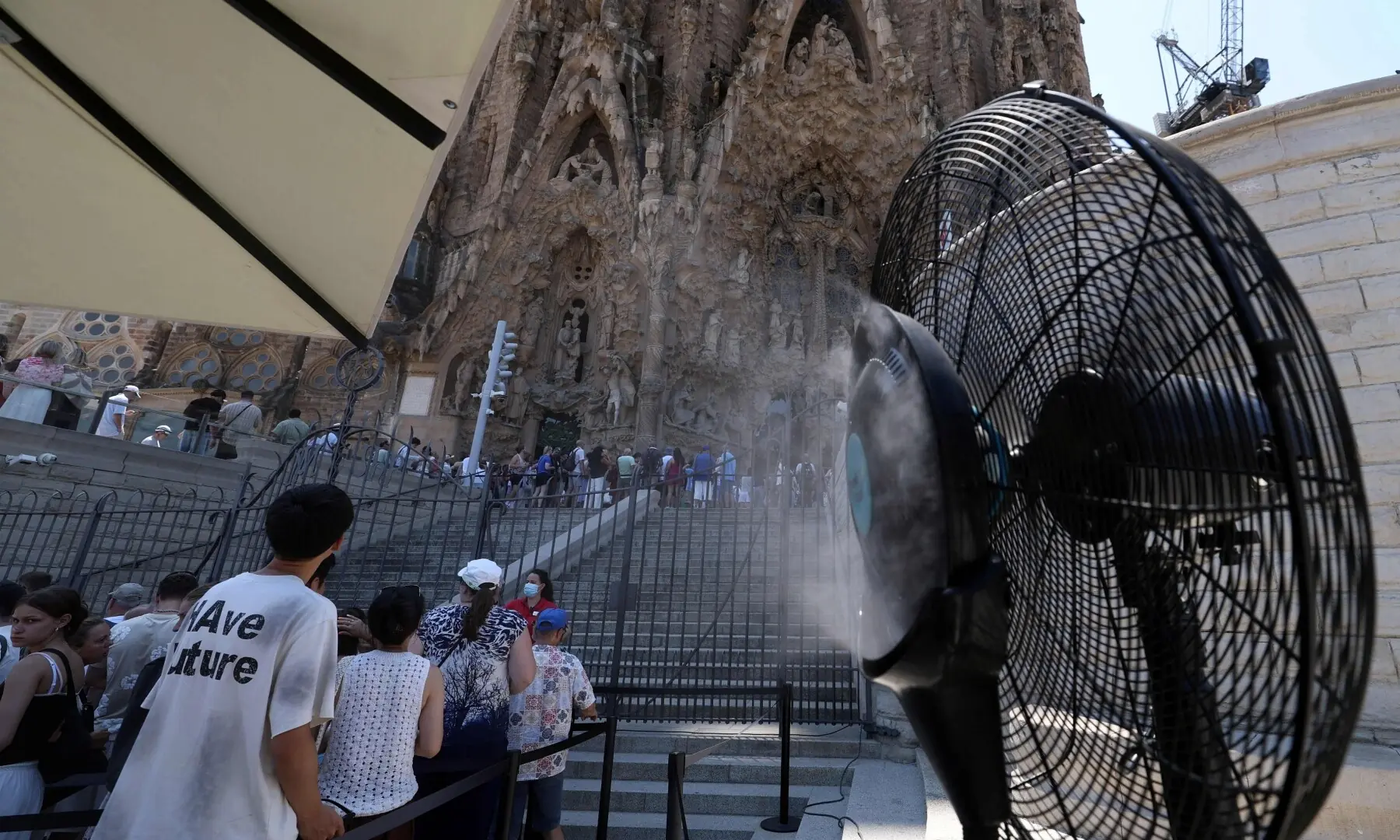 A humidifying fan is pictured during a heatwave as tourists visit La Sagrada Familia in Barcelona on July 7, 2026. — AFP