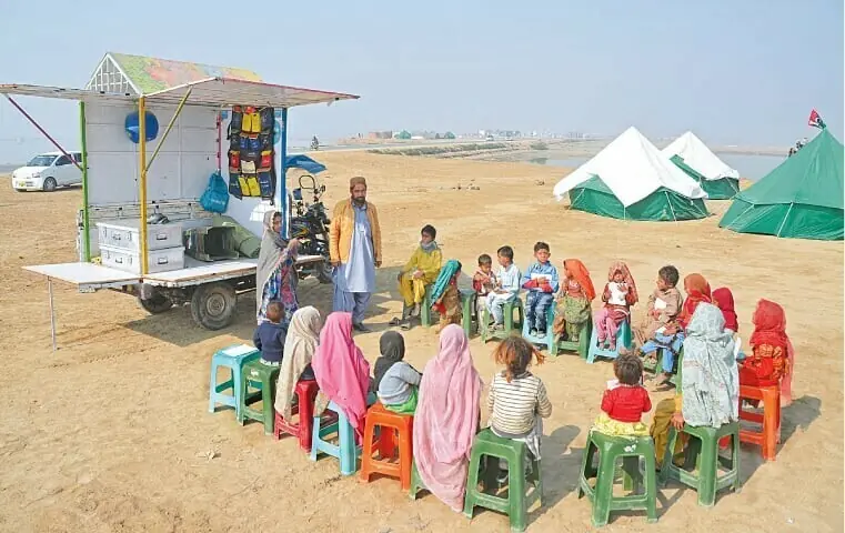 Dera Allah Yar: Flood-affected children attend a class at a mobile school set up in a camp housing flood-hit people. —AFP/File Dera Allah Yar: Flood-affected children attend a class at a mobile school set up in a camp housing flood-hit people. —AFP/File