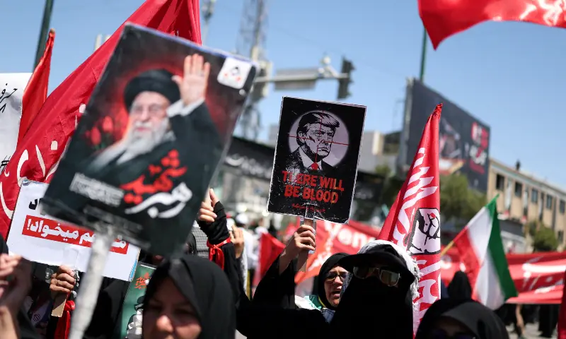 A woman holds a sign depicting US President Donald Trump as mourners gather on the day of the burial of Iran&rsquo;s late Supreme Leader Ayatollah Ali Khamenei, in Mashhad, Iran on July 9, 2026. &mdash; Reuters