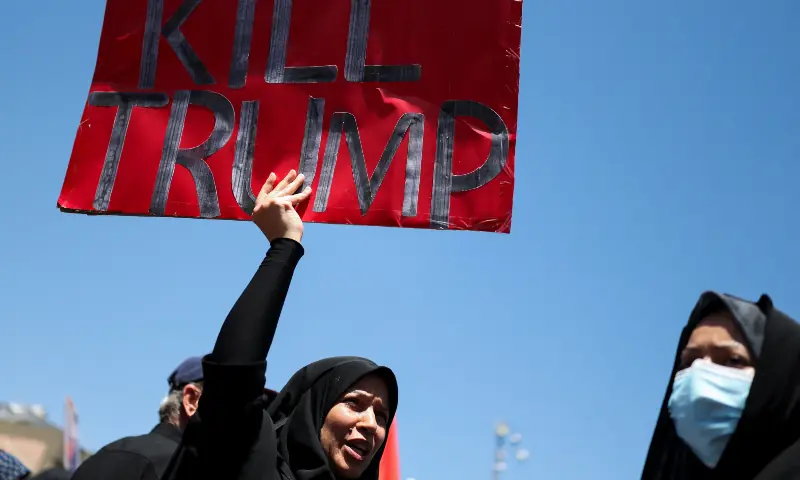 A woman holds an anti-Trump sign as mourners gather during a funeral procession on the day of the burial of Iran&rsquo;s late Supreme Leader Ayatollah Ali Khamenei, in Mashhad, Iran on July 9, 2026. &mdash; Reuters